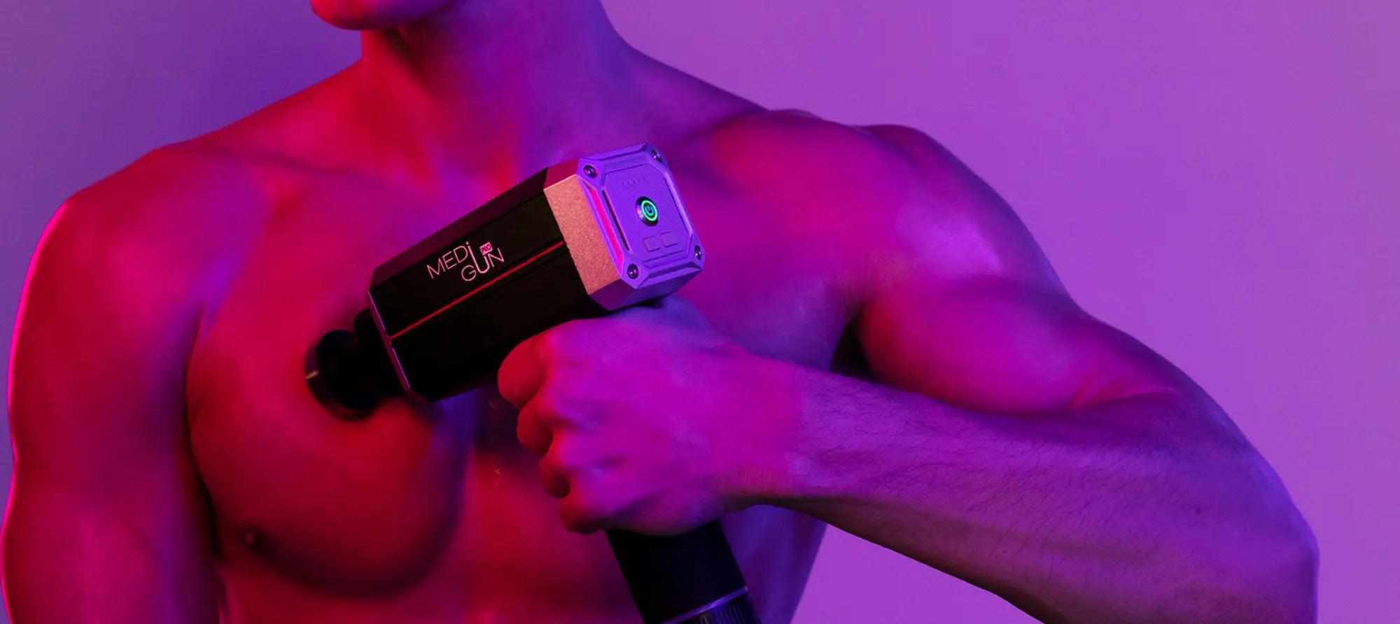 Mężczyzna wykonujący masaż mięśnia piersiowego pistoletem wibracyjnym MediGunPRO