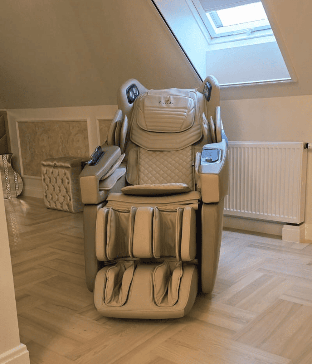 Beżowy fotel masujący ustawiony w pokoju na piętrze przed oknem