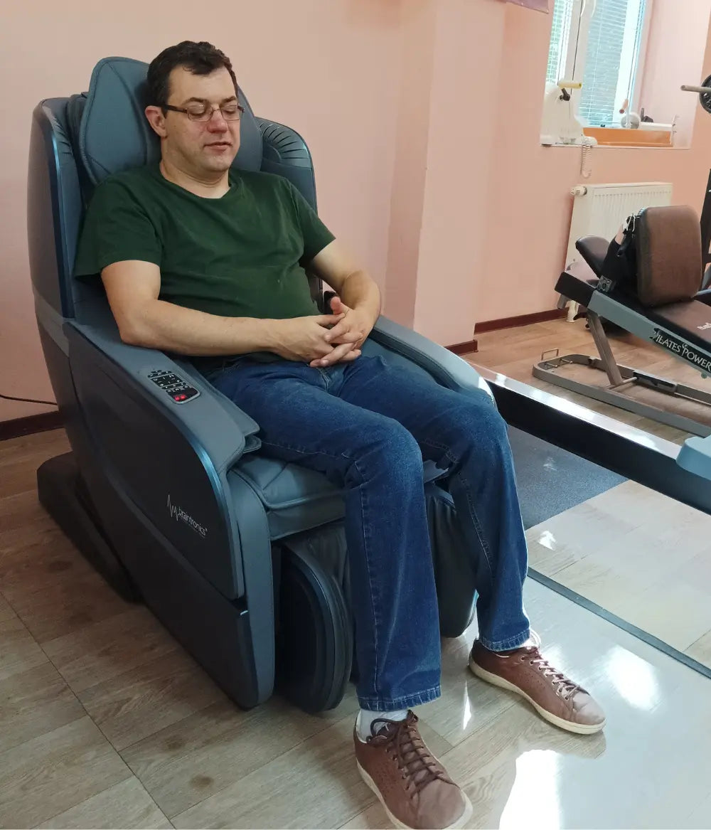 Mężczyzna na fotelu masującym Ecosonic w sali ćwiczeń